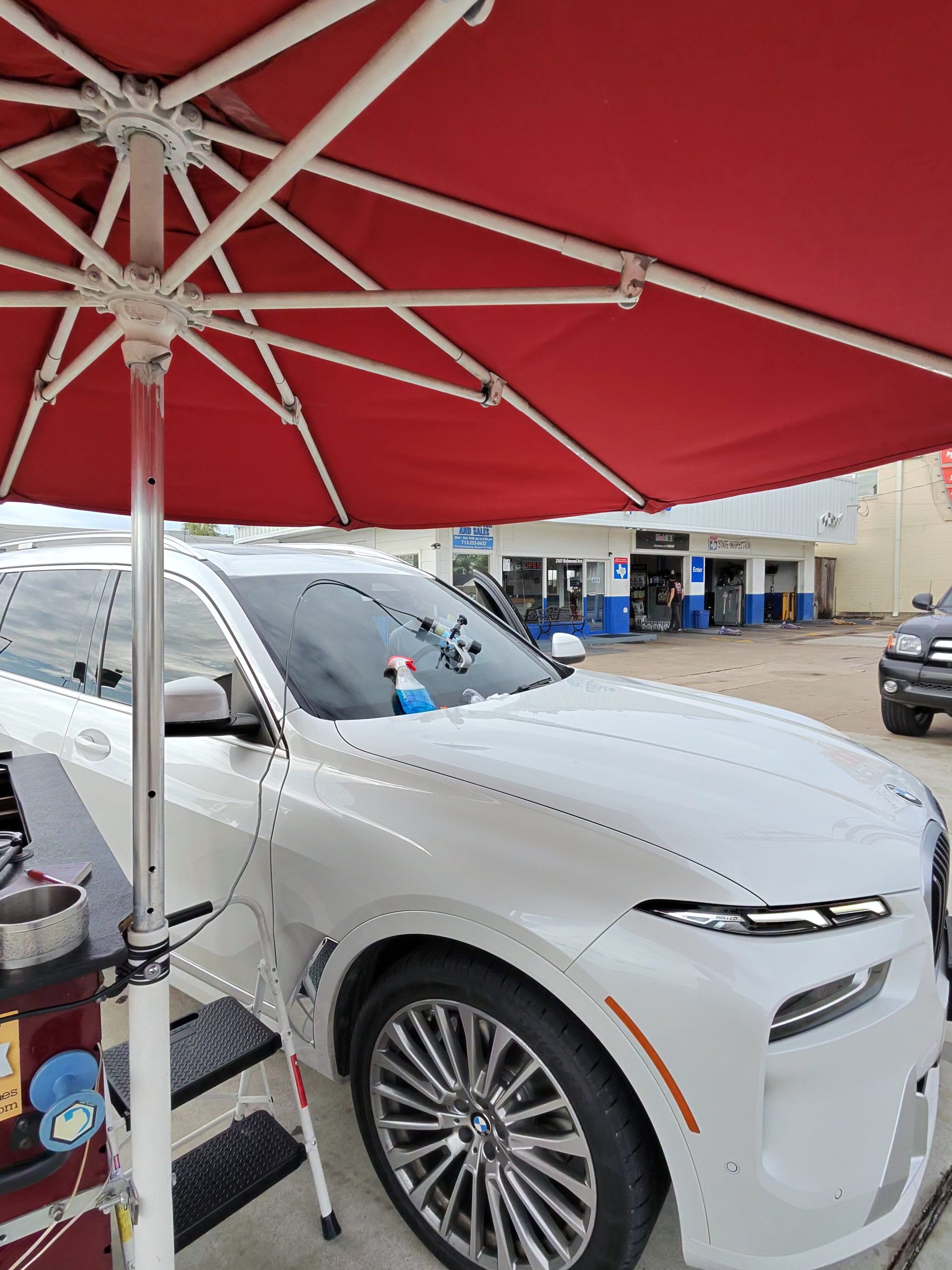 White BMW Windshield Chip Repair Under Umbrella - Houston TX
